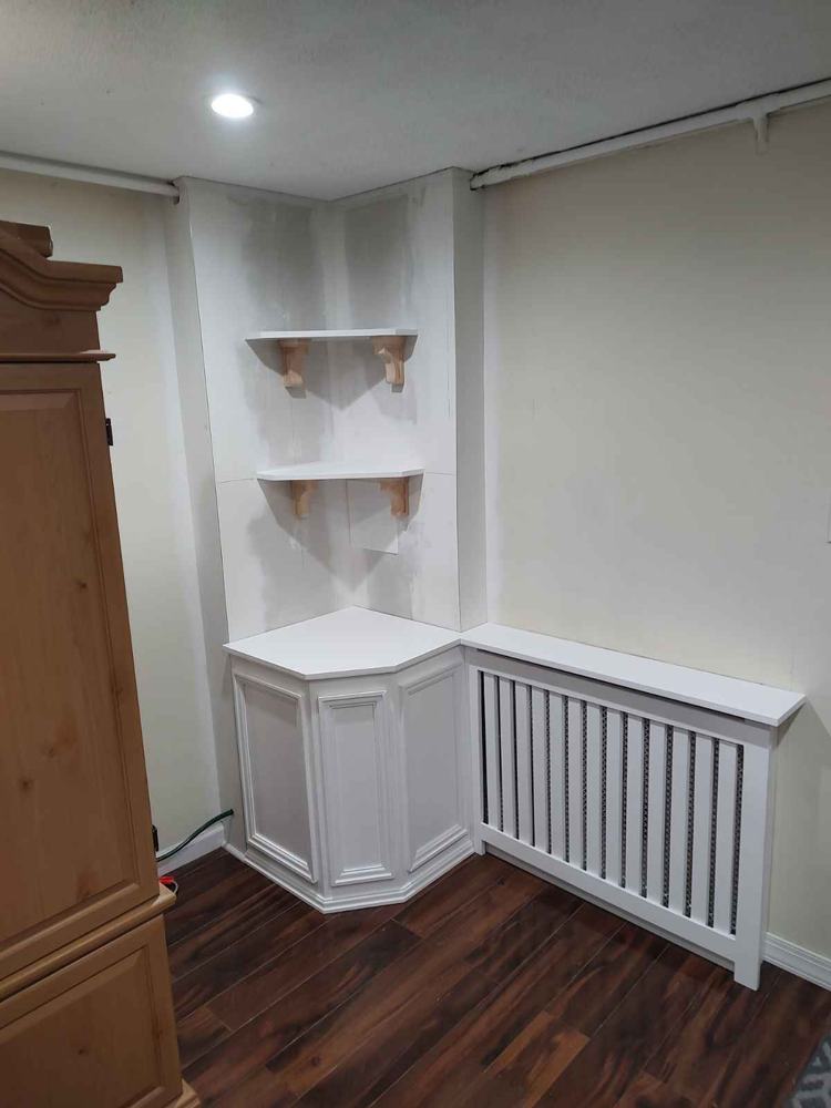 Finished corner with custom radiator cover and shelving by AB6 Carpentry