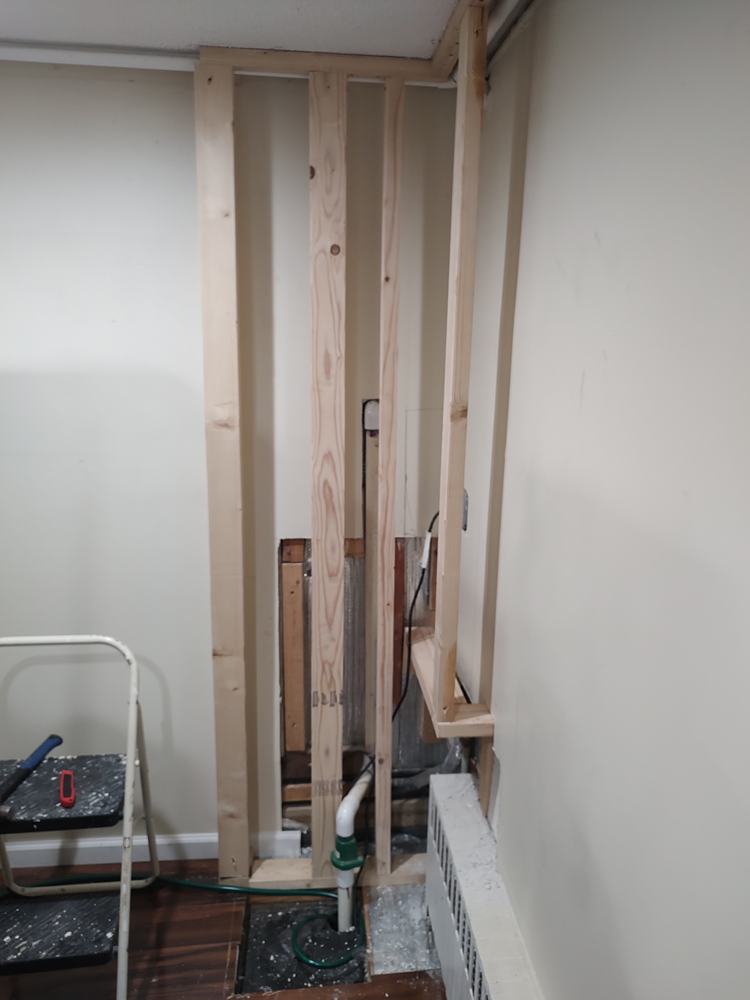 Opened wall and sump pump work before AB6 Carpentry finish