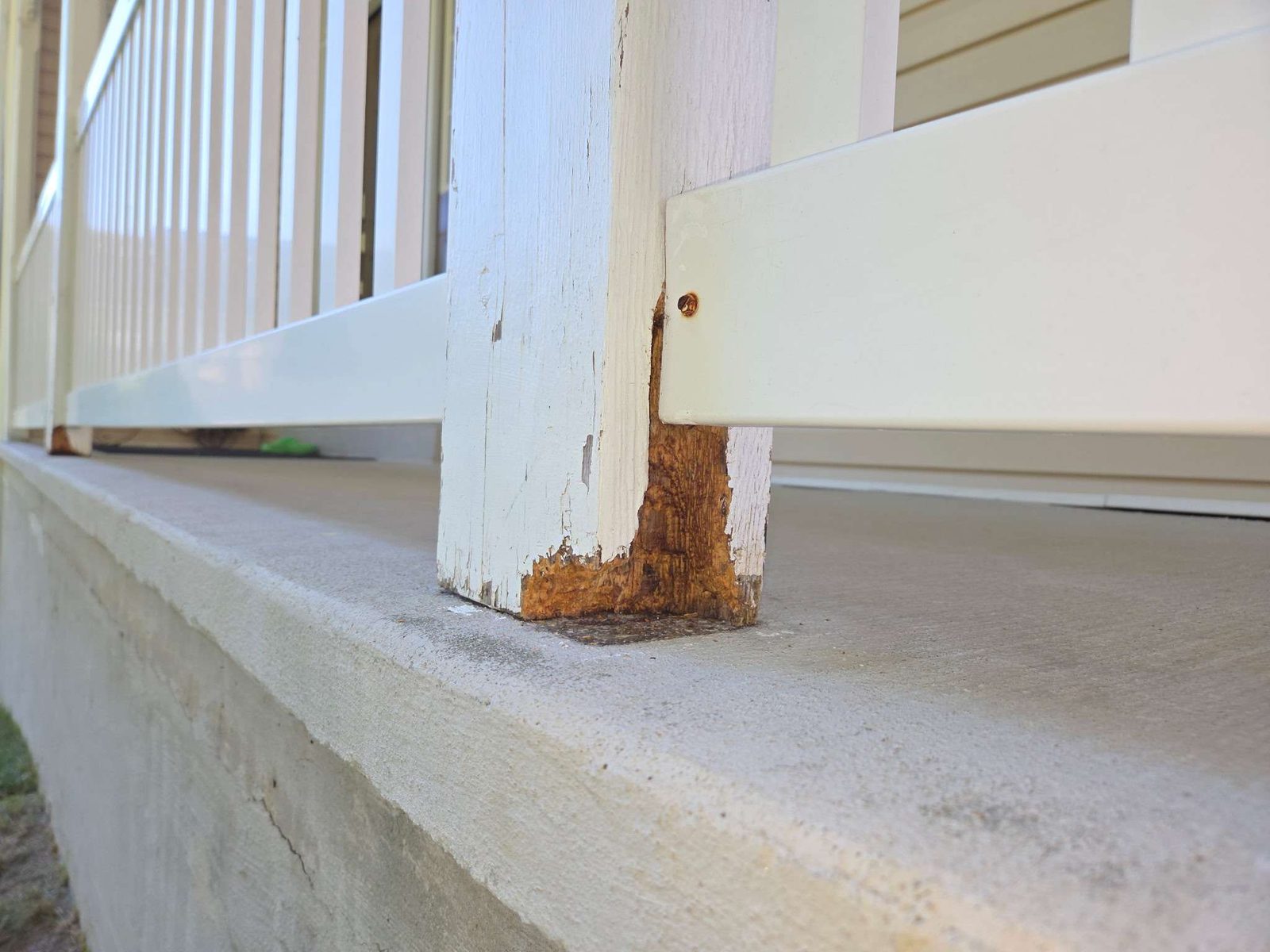 Porch post rotted at the base where it sits on concrete
