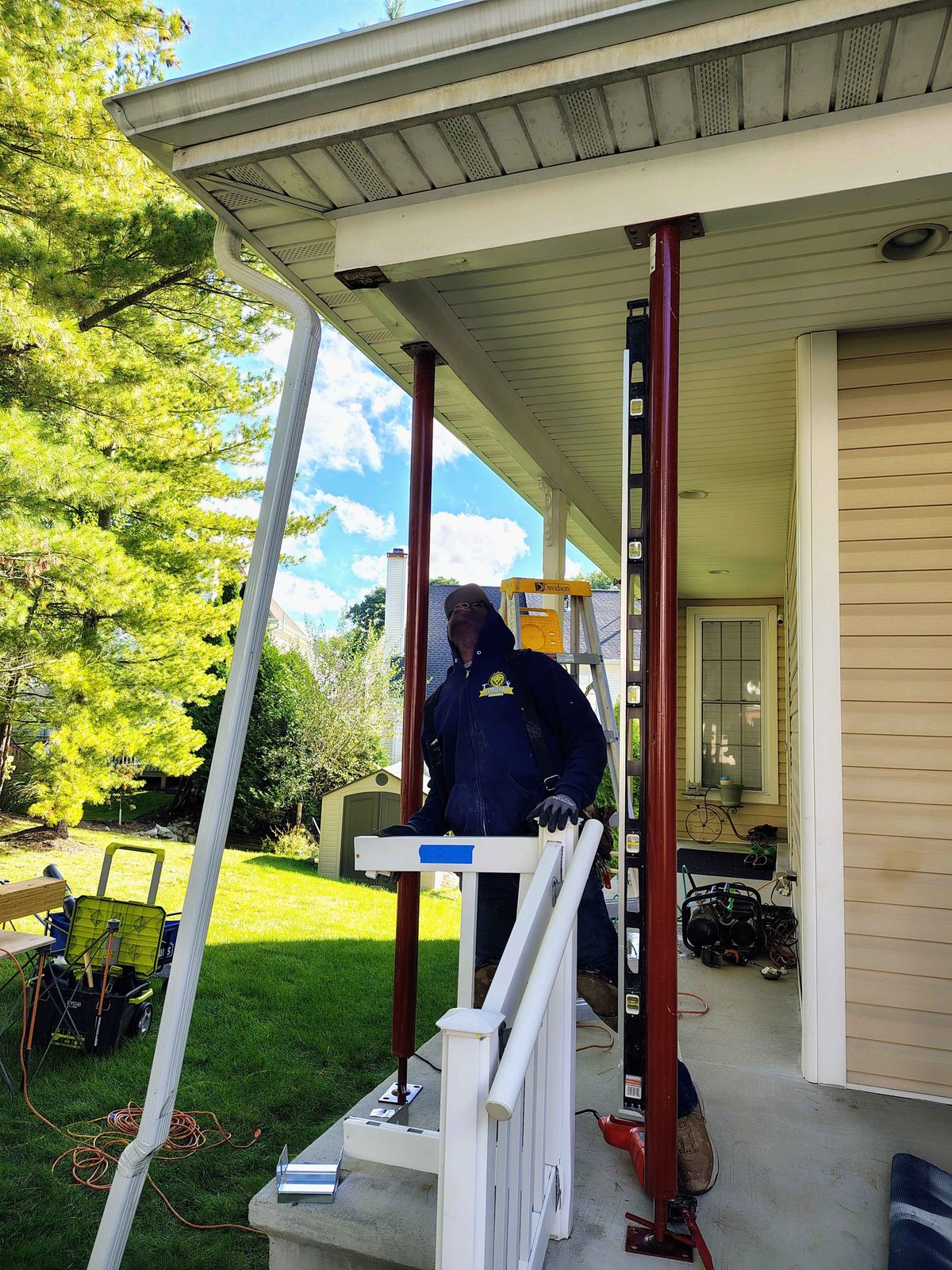 Porch roof shored with steel jacks while AB6 Carpentry replaces the rotted posts